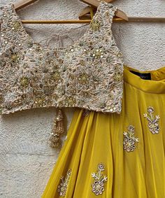 Mustard Yellow Georgette lehenga embellished with floral hand embroidered buttis and a shimmering gold border teamed with a beige gold raw silk blouse intricately hand embroidered with mirror, resham, zardozi, beads and cutwork details. Completed with a mustard yellow soft net dupatta with mirror work highlights and a gold zari border Composition : Lehenga - Georgette, Blouse - Raw Silk, Dupatta - Soft Net All products can be customised for sleeves, length of blouse and neck design Delivery : 2- Yellow Mirror Work Sets For Reception, Yellow Sets With Mirror Work For Reception, Yellow Palazzo Set For Reception And Navratri, Navratri Reception Palazzo Set With Gota Work, Gold Palazzo Set With Dori Work For Navratri, Gold Palazzo Set With Dori Work For Diwali, Yellow Palazzo Set With Zari Work For Reception, Yellow Chinon Palazzo Set With Dori Work, Yellow Palazzo Set With Dori Work In Chinon