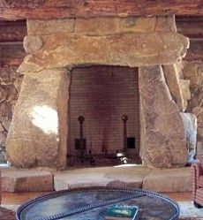 a living room with stone fireplace and couches