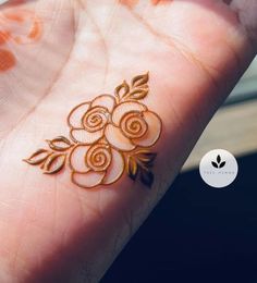 a person's hand with henna tattoos on it and an orange circle around the wrist