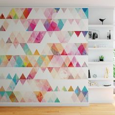 an abstract wall mural in a living room with wood floors and white shelving units