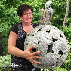 a woman is holding a sculpture in her hands