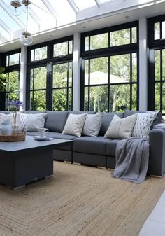 a living room filled with furniture and large windows