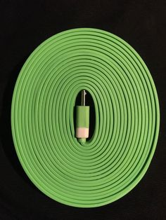 a close up of a green hose on a black background