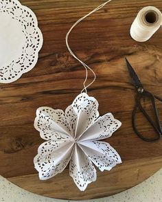 some paper doily and scissors on a wooden table