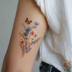 a woman's arm with flowers and butterflies tattoo on the left side of her arm