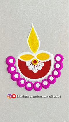 an embroidered diya with flowers and dots on the bottom is shown in red, yellow and white