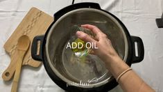 someone is adding oil to an empty pot