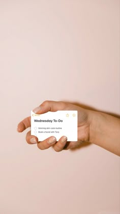 a hand holding a business card that says wednesday to do