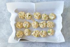 an overhead view of some appetizers on a white tray with parchment paper in the middle