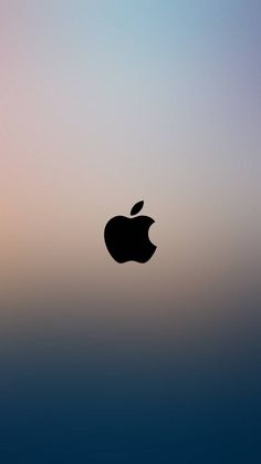 an apple logo is shown in front of a blurry blue and pink sky background