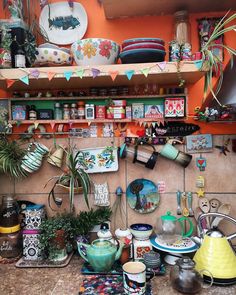 a kitchen counter with pots and pans on top of it next to a shelf filled with dishes