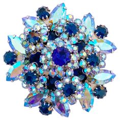 - Vintage item - 2" diameter - 1" depth - Rhodium plated (silver tone) - Prong set blue Aurora Borealis (AB) iridescent navette crystal rhinestones - Prong set navy blue round crystal rhinestone accents - Manufactured by DeLizza & Elster for Vendome (signed on verso) - Circa 1960s - Estate acquired - This item has been cleaned & polished and is ready to wear - Excellent vintage condition Blue Round Brooch For Formal Occasions, Formal Blue Round Brooch, Formal Blue Round Brooches, Layered Cocktails, 1970s Jewelry, Blue Aurora, Costume Jewelery, Blue Aurora Borealis, Vintage Rhinestone Jewelry