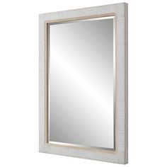 a white framed mirror sitting on top of a wall