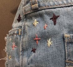 a pair of blue jeans with red and yellow stars on them are seen in close up