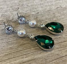 Long Green Earrings Emerald Green Rhinestone Earrings Pear Shape with Swarovski Pearl wedding bridal jewelryThese  Bridal Earrings in Emerald Green Crystal Rhinestone are so pretty with a Long Green Pear Shaped Drop that measures a total of  2 inches long. Made with a Swarovski Pearl in your choice of color either White (shown) or Cream Ivory, these also have a CZ Rhinestone post on the top.Comes in a Gift Box and ready to give. Perfect wedding bridal or gift!To see more Bridal Wedding Jewelry v Green Crystal Rhinestone Earrings For Wedding, Green Rhinestone Crystal Earrings For Wedding, Wedding Green Crystal Rhinestone Earrings, Emerald Green Crystal, Emerald Green Earrings, Earrings Emerald, Historical Jewellery, Wedding Bridal Jewellery, White Jewelry