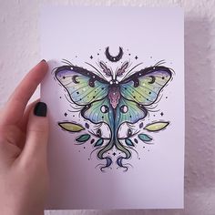 a hand holding up a card with a butterfly on it's wings and stars