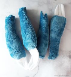 three blue and white stuffed animals on a marble surface