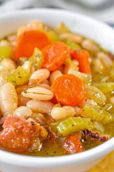 a bowl filled with beans, carrots and broccoli on top of a table