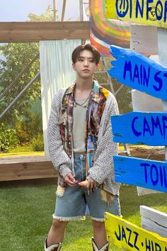 a young man standing in front of a sign