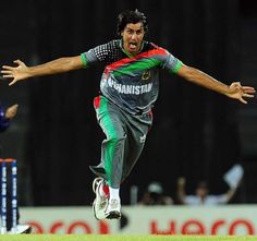 a man in grey and green uniform jumping up into the air with his arms outstretched