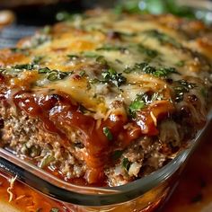 a casserole dish with meat, cheese and vegetables in it sitting on a table