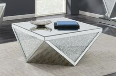 a mirrored coffee table sitting on top of a rug