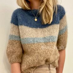 a blonde woman wearing a sweater and jeans