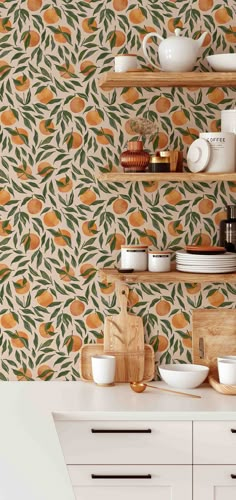 an orange wallpaper in a kitchen with wooden shelves and bowls on the countertop