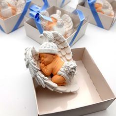 small baby angel figurines in white boxes with blue ribbons