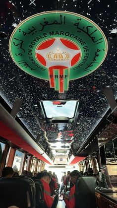 the inside of a bus with people sitting on seats and looking up at the ceiling