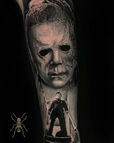 a man's arm with an image of a person wearing a mask and holding a knife