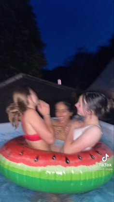 three girls in a watermelon float on the pool with their arms around each other