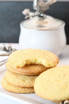 three cookies are stacked on top of each other with a tea pot in the background