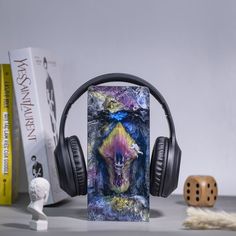 a book with headphones on top of it next to two books and a pair of dice