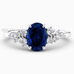 an oval blue sapphire and diamond ring with three stone accents on the band, set in 18k white gold