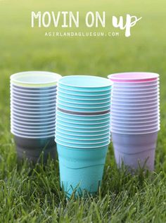 colorful cups sitting in the grass with words moving on up above them