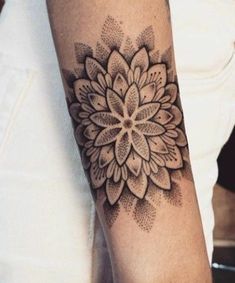 a woman's arm with a tattoo on it that has a flower in the center