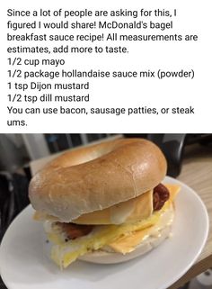 a breakfast sandwich with bacon, egg and cheese on a bagel bun is shown