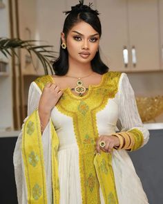 This elegant golden Habesha dress displays traditionally unique craftmanship with modern finishing and pattern style. The gorgeous essence of the dress offers beautiful look for any special occasions planned. Material Cotton Menen Thread Estimated delivery : 1 week to 2 weeks Contact WhatsApp +1(304)-306-2784Email: contact@ethiopian.store Traditional Yellow Wedding Kaftan, Gold Dresses With Zari Work, Yellow Dresses With Gold Embroidery For Festivals, Yellow Dress With Gold Embroidery For Festivals, Gold Anarkali Kaftan With Traditional Drape, Elegant Yellow Kaftan For Festive Occasions, Gold Dresses With Traditional Patterns For Ceremonies, Gold Dress With Traditional Patterns For Wedding, Elegant Yellow Dress With Zari Work