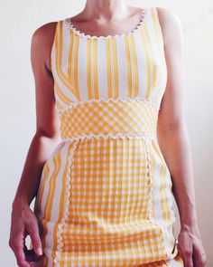 Step into timeless elegance with our Vintage 1970s Ruth Norman Yellow and White Checked & Striped Long Dress, a stunning piece that captures the essence of coquette American Gothic style. Flattering in form and designed for versatility, this dress is perfect for summer picnics, garden parties, and semi-formal events. The playful blend of checks and stripes in soft yellow and white adds a charming retro touch, making this dress a standout addition to any vintage wardrobe. Crafted with care, this long dress offers a figure-enhancing silhouette while keeping you comfortable and stylish during warm weather. Whether you're attending a casual outdoor gathering or dressing up for a special occasion, this vintage Ruth Norman dress is an ideal choice for those who love blending vintage sophisticati Americana Coquette, Checks And Stripes, Long Striped Dress, Race Day Outfits, Summer Picnics, Coquette Style, American Gothic, Vintage Wardrobe, Soft Yellow