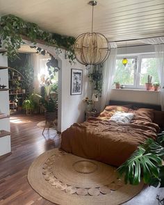 a bed room with a neatly made bed and lots of plants