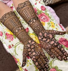 two hands with henna tattoos on them