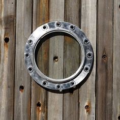 a metal ring mounted to the side of a wooden fence with rivets on it