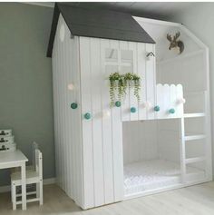 a child's bedroom with a white bunk bed and green plants on the roof