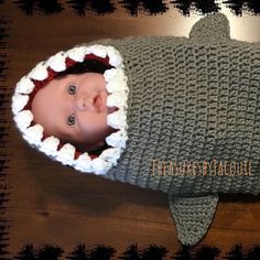 a baby wearing a knitted shark costume