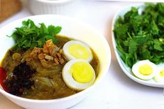 two bowls filled with different types of food and garnished with green leafy greens