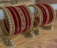 red and gold bracelets are hanging on a white pole