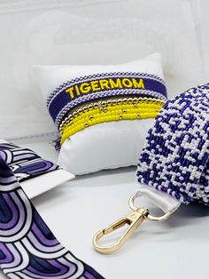 two decorative pillows and a keychain on a table with other items in the background