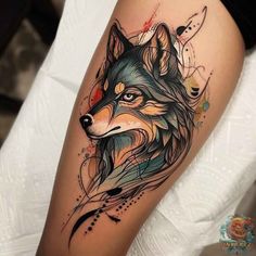 a tattoo on the leg of a woman with a wolf head and watercolor paint splat