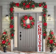 christmas wreaths and poinsettias are hanging on the front door